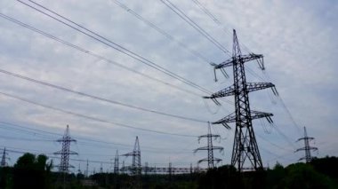 Akşamları elektrik kulelerinin silueti. Gökyüzünün altında yüksek voltajlı elektrik hatları. İletişim hatları. Doğada pek çok elektrik direği.