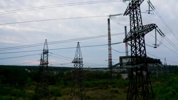 工場の背景にある電気タワー 有害な企業の近くの高圧電気パイロン 自然とテクノロジーの概念 カメラアップ — ストック動画