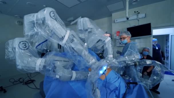 手術室に手術用腕を搭載したロボット 病院でロボット技術を用いた現代手術 侵襲的な外科的イノベーション — ストック動画