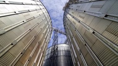 Tahıl ambarı asansörleri. Depolama mahsulü için metal tanklar. Çiftçilik için büyük kutular. Mavi gökyüzüne karşı alüminyum kaplar. Yakın plan..