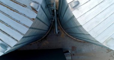 Büyük metal bir hangar. Tahıl asansörleri açık havada. Tahıl depolamak için alüminyum kaplar. Tarım işi. Modern endüstriyel fabrika. Aşağı hareket.