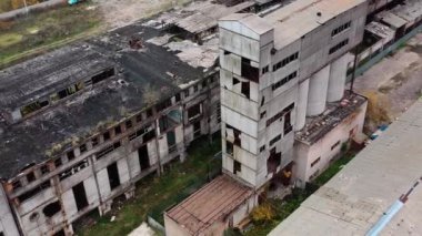 Hasarlı çatısı olan mahvolmuş bir fabrika. Askeri harekat alanında terk edilmiş binalar. Mahvolmuş mimari. Hava görünümü.