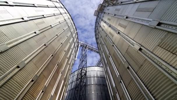グラナリーグレーンエレベーター 貯蔵作物のための金属タンク 農業のための大きなビン 青空に対するアルミ容器 クローズアップ — ストック動画