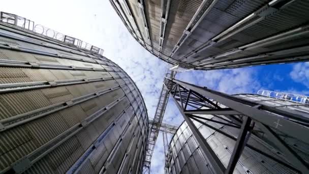 現代の穀物ターミナル 穀物を乾燥するための金属貯蔵タンク アグリビジネスのための産業機器 青空を背景にした大型グレーンエレベーター クローズアップ — ストック動画
