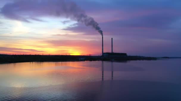 日落时河上的化工厂 晚上工业工厂向空气中排放有害的烟雾 相机升起了 — 图库视频影像