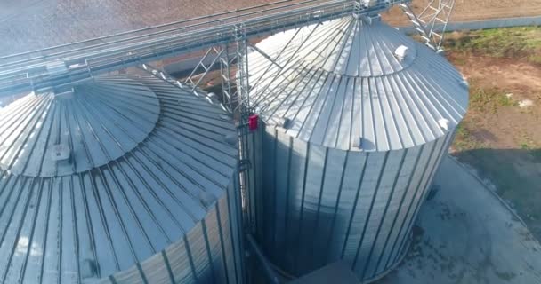 球场上的金属筛子储存和加工谷物的大型容器 农田里的银谷物电梯 空中景观 — 图库视频影像