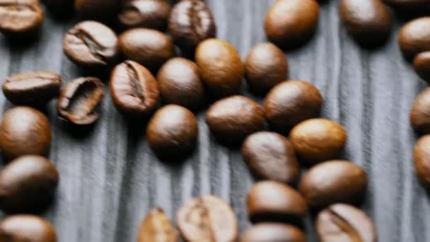 Σπόροι Καφέ Καφέ Καβουρδισμένοι Κόκκοι Καφέ Σκορπισμένοι Στην Ξύλινη Επιφάνεια — Αρχείο Βίντεο