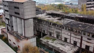 Eski terk edilmiş fabrika. Askeri faaliyetlerden sonra çatıda bir sürü deliği olan harabe binaların dışında. Dışarıdaki hasarlı binalar. Hava görünümü.