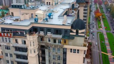 Şehirdeki yüksek bir binanın inşaatı. Şehirde modern apartman blokları inşa ediliyor. Pencereli yeni kule mimarisi. Hava görünümü.