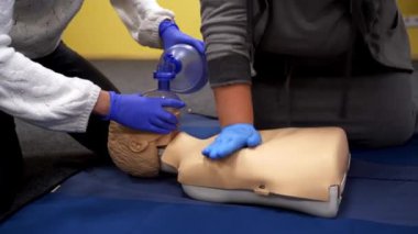 Tıbbi bir manken üzerinde çalışıyorum. İnsanlar kardiyopulmoner resüsitasyon yapıyor. Bir kuklanın göğüs sıkışması prosedürü.