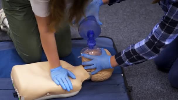 緊急援助コースのトレーニング マニキンに関する最初の援助Cpr蘇生訓練 無菌手袋の女性 ダミーの呼吸器具 — ストック動画