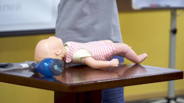 ファーストエイドトレーニング 女性は心肺再生訓練のために人形のダミーでCprを行う方法を示しています マネキン人形の医療デモ — ストック動画