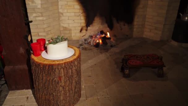 冬の家で快適なインテリア 暖炉の背景にあるマグとお祝いのケーキ 居心地の良い新年の気分 — ストック動画