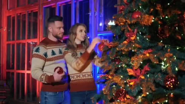 Young Couple Decorates Christmas Tree Happy Guy Beautiful Girl Getting — Stock Video