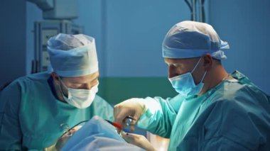 Cerrahlar tıbbi aletlerle çalışır. Profesyonel doktorlar klinikte estetik ameliyat yaparlar. Bir hasta için Blepharoplasty.