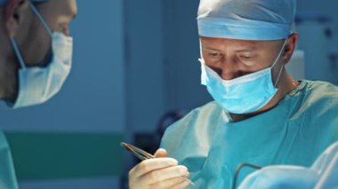 Estetik ameliyat yapan cerrahların takım çalışması. Hastanede bifaroplasti yapan tıp uzmanları. Kozmetik ameliyat sırasında doktorlar. Yakın plan..