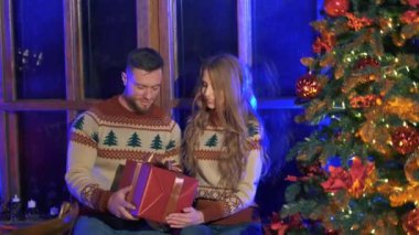 Yetenekli romantik bir çift. Güzel bir kadın ve yakışıklı bir adam Noel zamanı büyük bir hediye kutusu tutuyor. Noel ağacının yanında örülü süveter giyen sevimli bir çift..