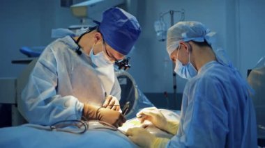 Tıbbi uzmanlar beyin cerrahisi yapar. Operasyon sırasında tıbbi aletlerle çalışan mavi üniformalı doktorların takım çalışması.