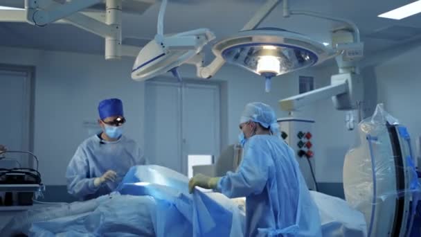 現代オペレーティングルームの外科医 オペレーティング シアターで働く医師のグループ 病院の外科機器について — ストック動画