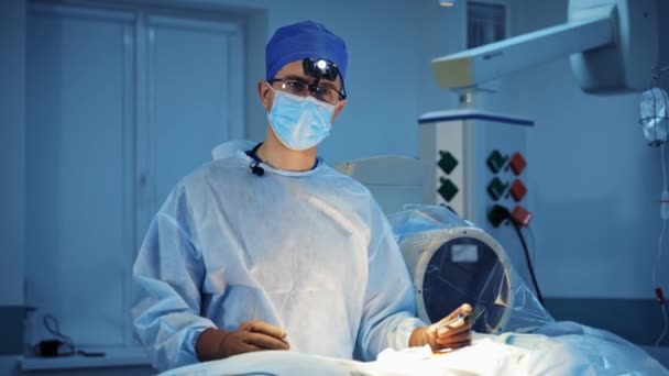 Retrato Cirurgião Máscara Lanterna Cirúrgica Médico Profissional Fala Sobre Câmera — Vídeo de Stock