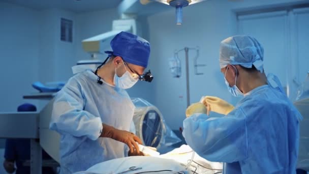 外科医のチームワーク 病院の手術室で医療機器を使用した医師とアシスタントの手術 医療コンセプト — ストック動画