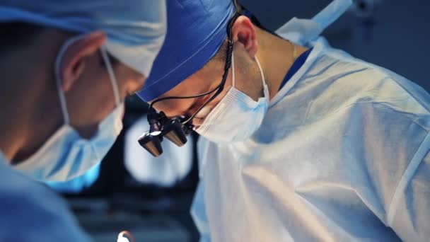 神経外科医が手術しています 手術プロセス中に外科用具を使用する医療マスクの専門外科医 クローズアップ — ストック動画