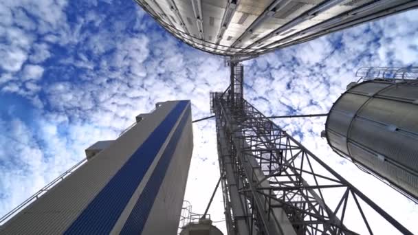 巨大なグレーンエレベーター アグリビジネスプラントの高い産業構造 空の背景に対する貯蔵タンク オービットショット 下からの眺め — ストック動画