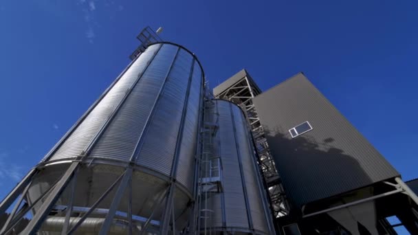 外面的银质容器现代农业综合体与蓝天相抗衡 大型谷物升降机 工业厂房 从下面看 — 图库视频影像