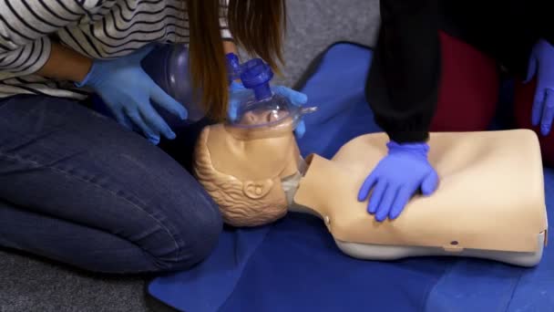マネキンのトレーニング再生手順 人々は練習コース中にダミーの顔に呼吸器具を使用します 患者に最初の援助を与えるためのトレーニング — ストック動画