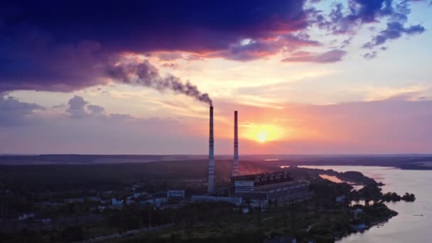 産業は自然を汚染する 日没時の田舎の川付近の化学プラント 夜に空気中に放出された産業パイプからの煙 — ストック動画