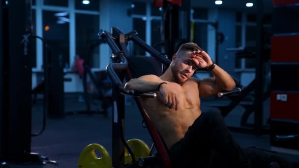 体育中心的运动员 运动模拟器上的肌肉男 运动员在体育馆里训练和喝水时感到很疲倦 — 图库视频影像