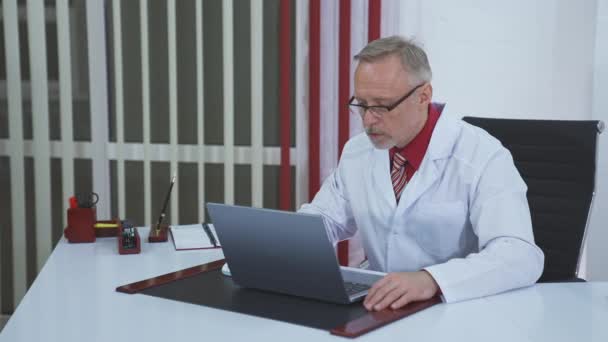 Médico Mayor Haciendo Videollamadas Laptop Médico Masculino Mayor Hablando Con — Vídeos de Stock
