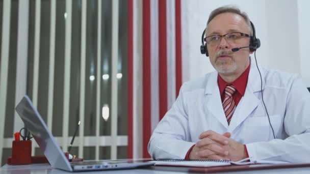 Doktor Sluchátky Kameře Ordinaci Profesionální Lékař Bílém Lékařském Kabátě Sedí — Stock video