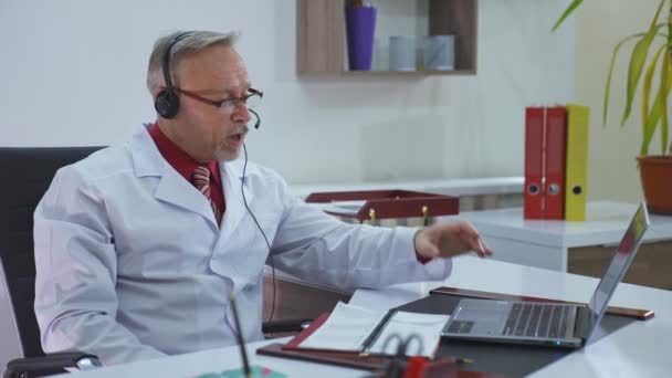 Stary Lekarz Gabinecie Medycznym Pracuje Online Profesjonalny Lekarz Okularach Płaszczu — Wideo stockowe