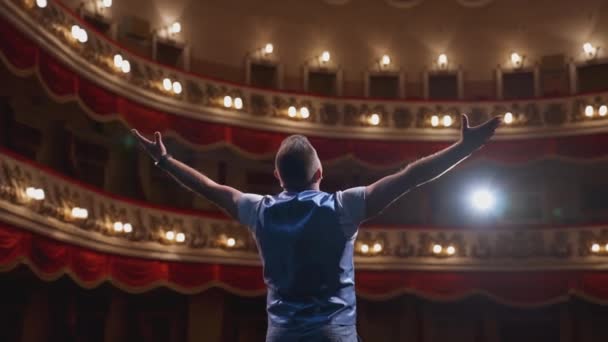 男人表演的姿势在舞台上 无法辨认的演员站在古典剧场的舞台上 男演员在现场讲话 背景色 — 图库视频影像