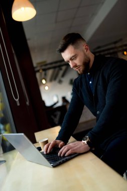 Dizüstü bilgisayar kullanarak masada oturan bir adam. Üretken Takip: Dizüstü bilgisayarında Çalışan Bir Adam