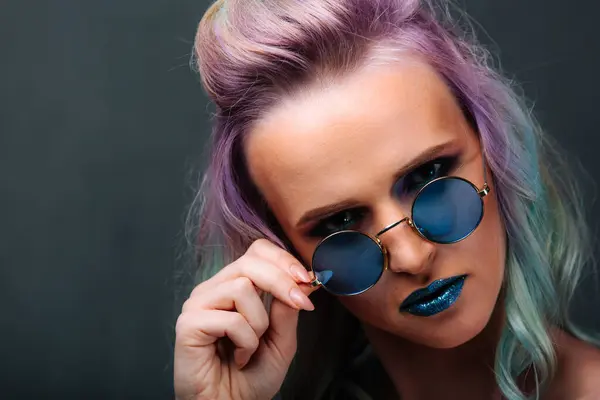 A woman with purple hair and blue sunglasses. The Colorful Rebel: A Woman with Vibrant Purple Hair and Stylish Blue Sunglasses