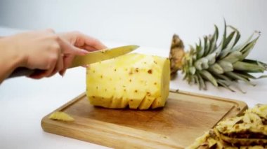 Ananas dilimleyen eller. Masada bıçakla olgun ananas dilimleyen kişi.
