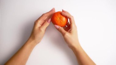 Eller mandalinayı tutuyor. Mandalina tutan kadın ellerine yakın çekim