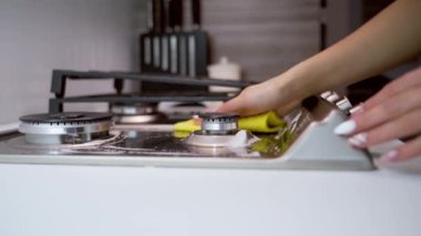 El temizleme fırını. Mutfaktaki gaz sobasını temizleyen kadın elini kapat.