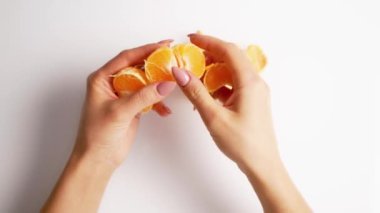 Kadın ellerinde soyulmuş mandalina. Beyaz arkaplanda Mandarin 'i kapat