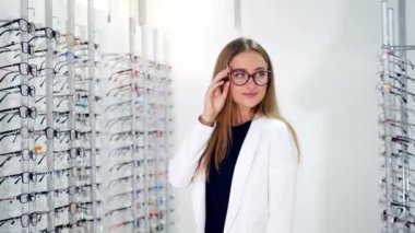 Optik merkezde gözlük takan bir kadın. Farklı şekil ve renkte gözlükler almaya karar veren tatlı bir kız.