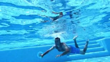Yüzme havuzunda bir adam. Havuzda yüzen adamın sualtı görüntüsü.