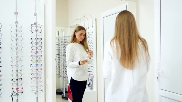 Kvinnan Väljer Glasögon Ung Flicka Provar Glasögon Framför Spegeln — Stockvideo