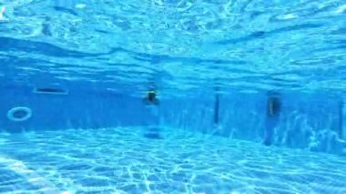 Mutlu çocuk suyun altında. Çocuk havuzda su altında yüzüyor.