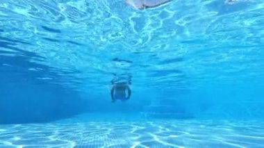 Havuzda yüzen adam. Genç adamın havuzda yüzerken sualtı görüntüsü.