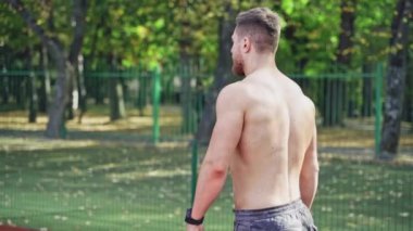 Stadyumda poz veren kaslı bir adam. Stadyumda duran güçlü ve yakışıklı genç sporcu.