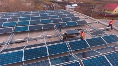 Çatıda Güneş Hücresi Yükleniyor. İşçiler bir binanın çatısına enerji tasarruflu güneş panelleri kuruyorlar