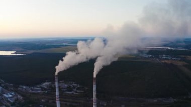 Dumanlı boruların görüntüsü. Mavi gökyüzünde beyaz dumanlı elektrik santrali