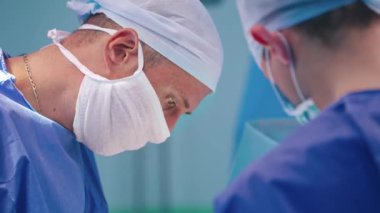 Ameliyat ekibi ameliyathanede. Cerrahın ameliyatının yan görünümü